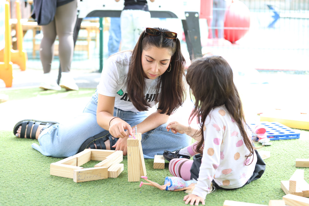 female link worker and child playing outdoors