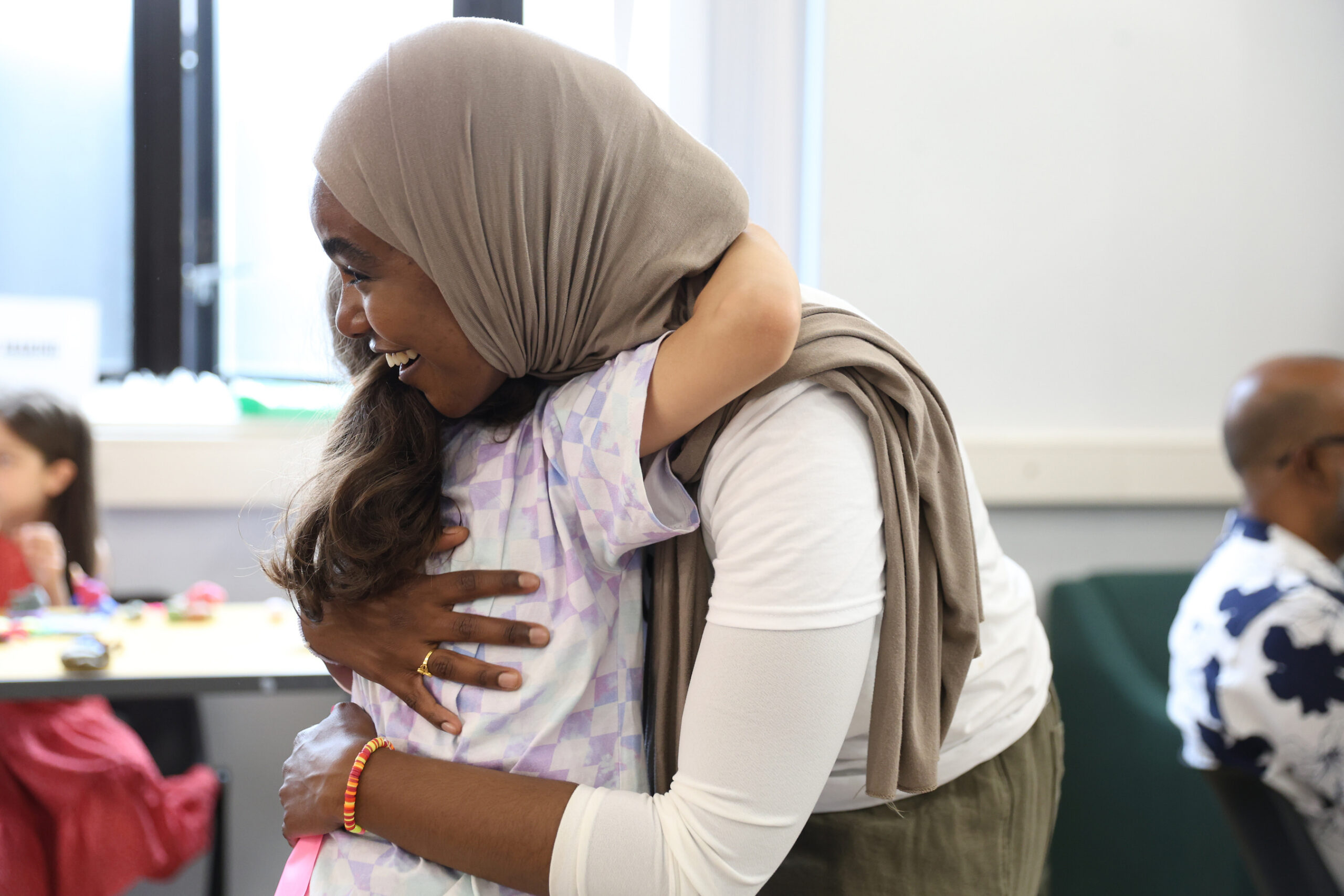 link worker hugging primary student in class