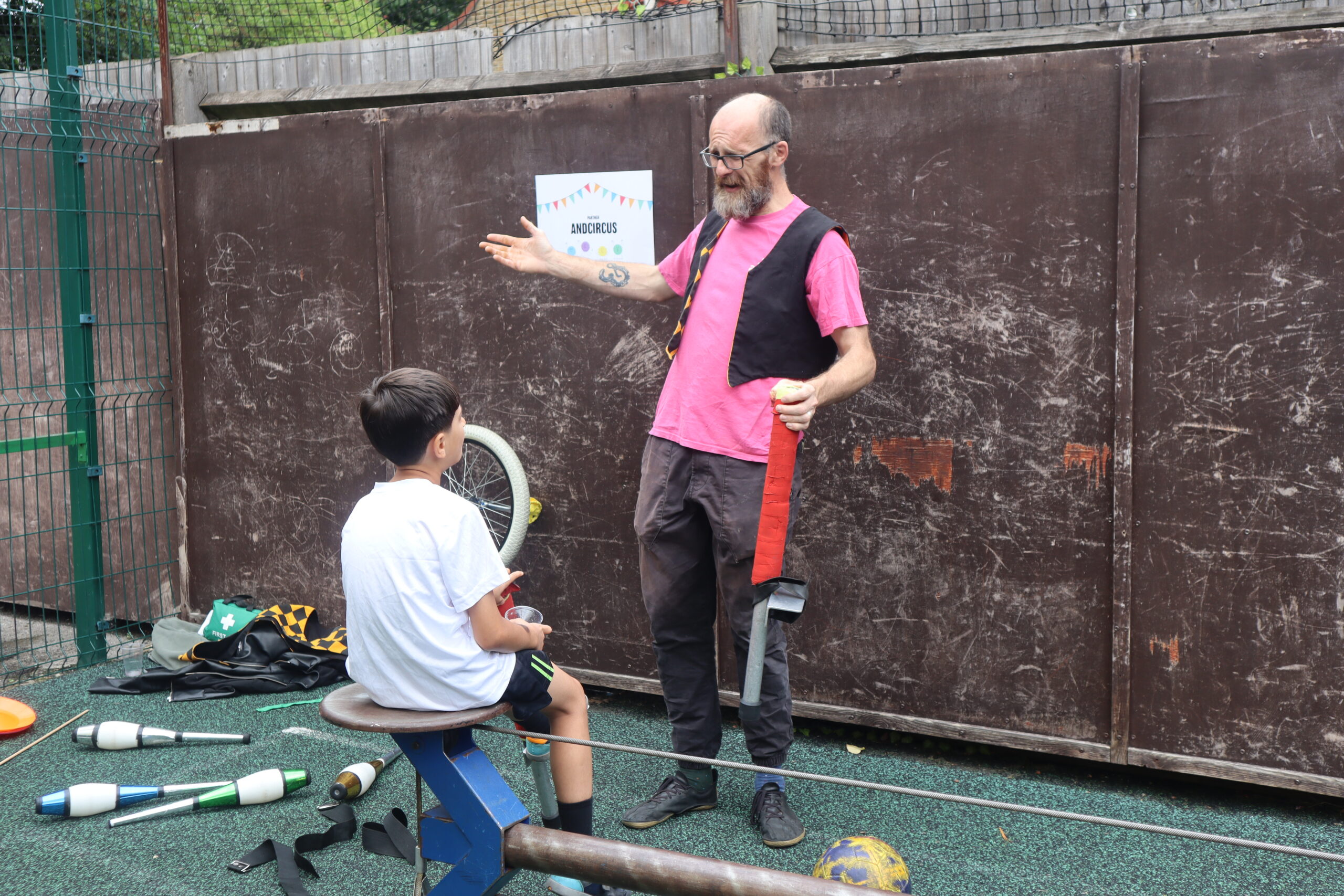 man teaching child circus skills outside