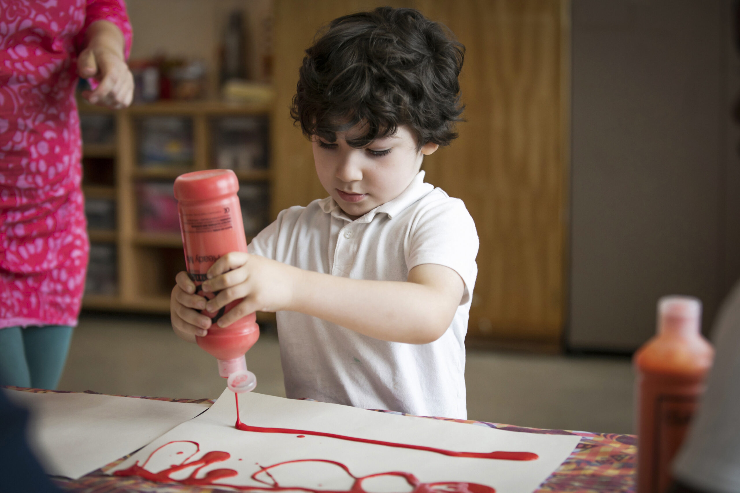 primary child painting in classroom